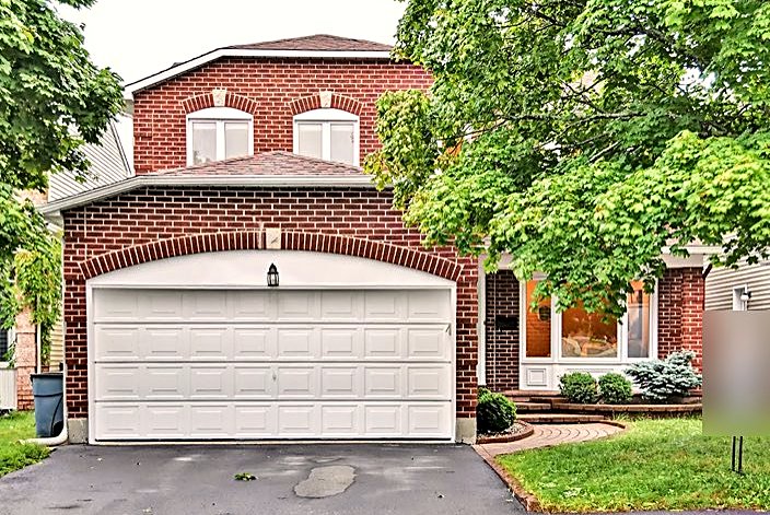 Front exterior of a sold red-brick detached home with double garage